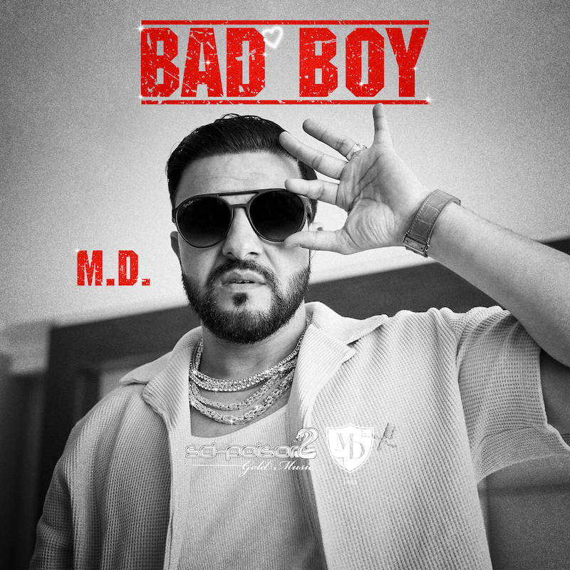 King M.D. trägt eine Sonnenbrille, offenes Shirt und eine Menge grosse Ketten. Das Bild ist das Song Cover vom Lied Bad Boy.